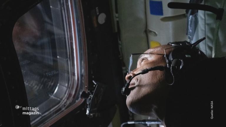 Astronaut schaut aus dem Fenster des Raumschiffs