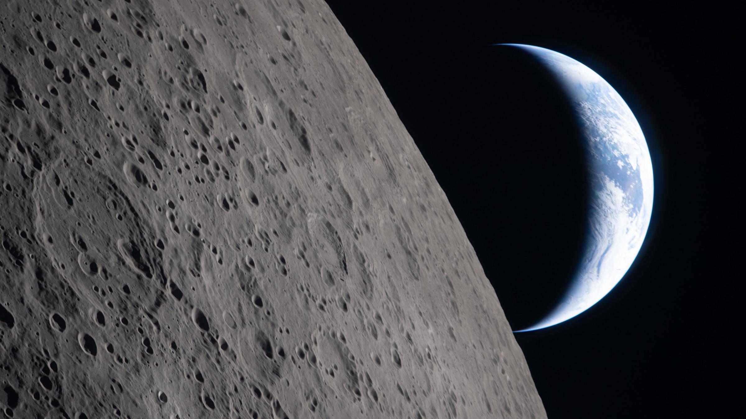 In diesem von der Nasa bereitgestellten Foto sieht man die Mondoberfläche im Vordergrund und die Erde im Hintergrund. Aufgenommen von der Crew der Artemis II.