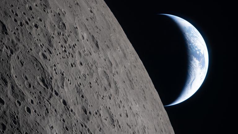 In diesem von der Nasa bereitgestellten Foto sieht man die Mondoberfläche im Vordergrund und die Erde im Hintergrund. Aufgenommen von der Crew der Artemis II.