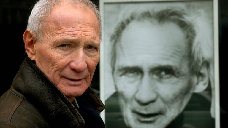 Schauspieler Arthur Brauss vor einem Foto von ihm selbst