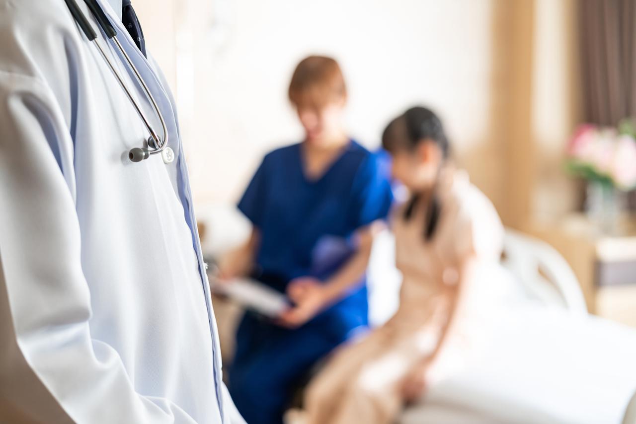 Arzt und Krankenschwester mit einer weiblichen jungen Patientin
