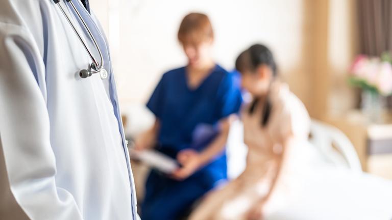 Arzt und Krankenschwester mit einer weiblichen jungen Patientin