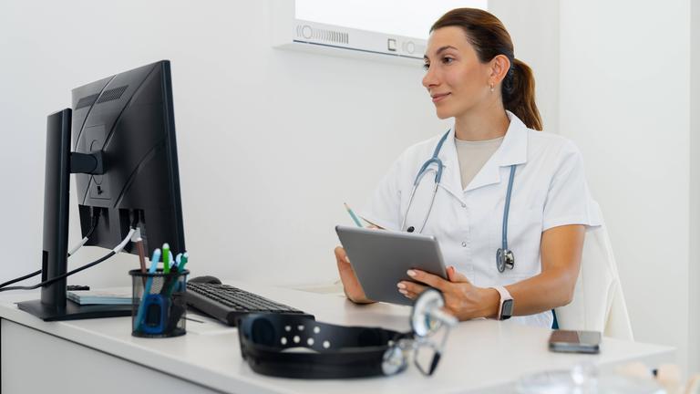 Arztberatung online mit digitalem Tablet in Arztpraxis