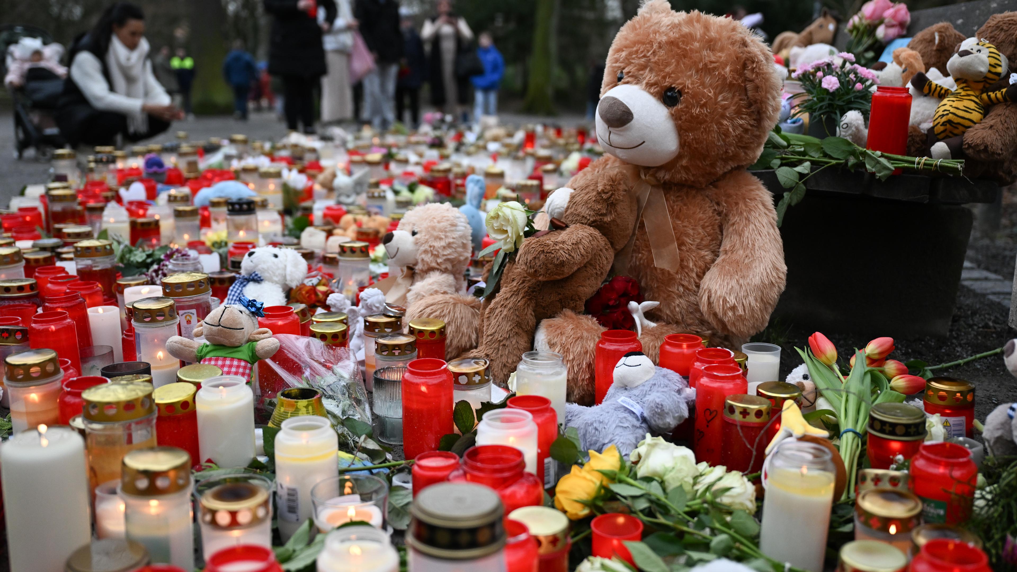 Viele Kerzen, Blumen und Plüschtiere sind in einem Park in Aschaffenburg als Zeichen der Anteilnahme niedergelegt. 