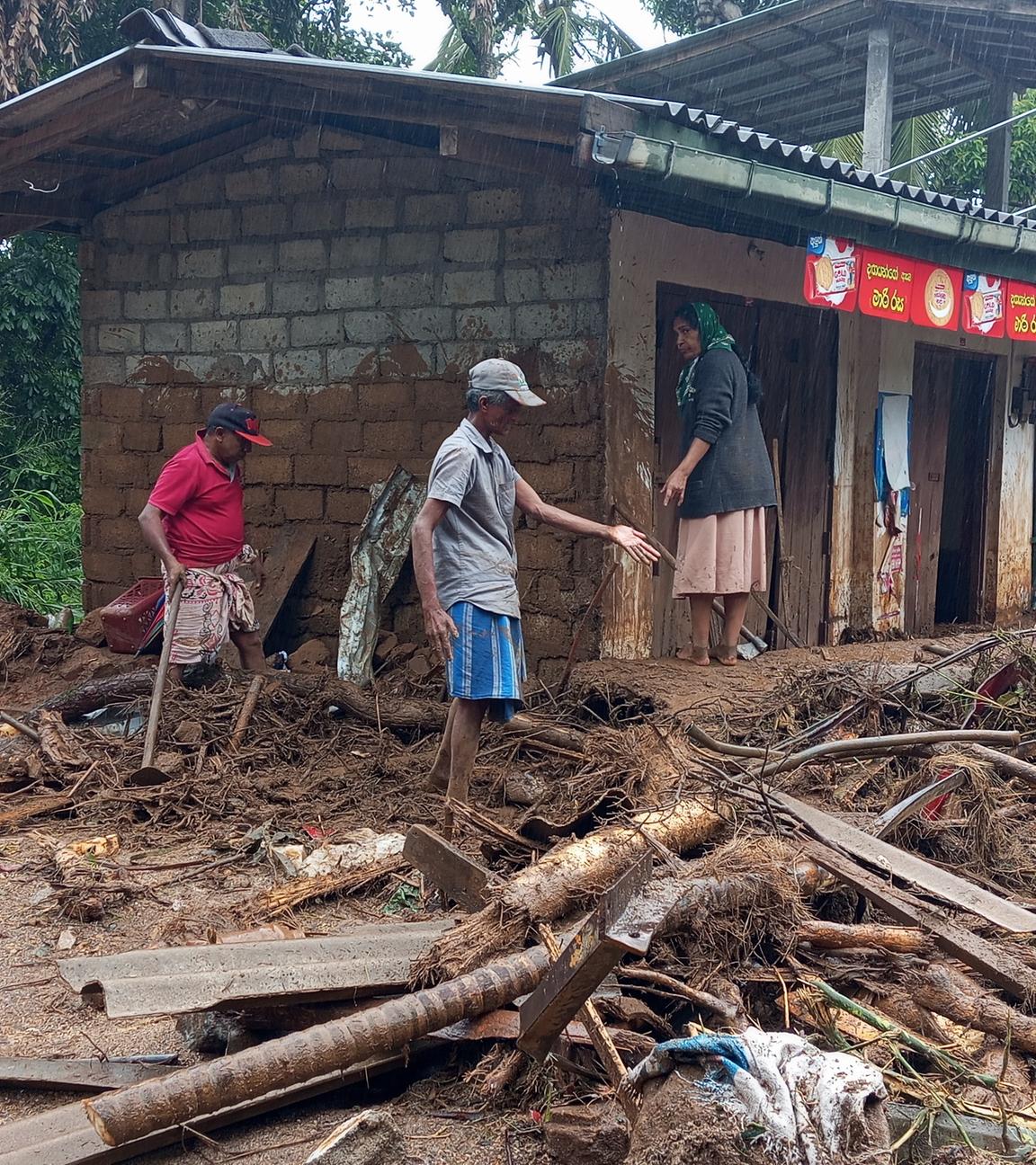 Überlebende eines Erdrutsches säubern die Trümmer.