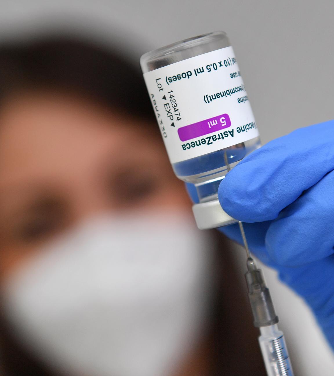 Impfspritze zieht Impfstoff aus einer Impfdose auf.