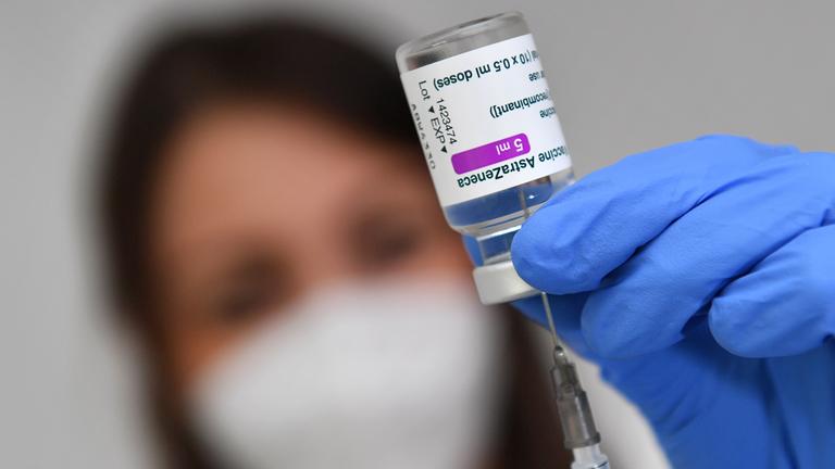 Impfspritze zieht Impfstoff aus einer Impfdose auf.