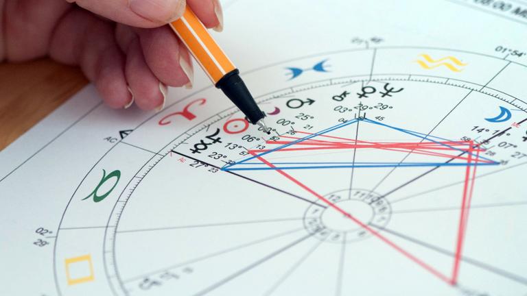 Eine Astrologin erstellt ein Horoskop.