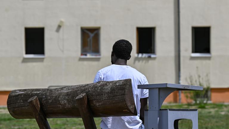 Ein Mann sitzt auf Gelände der zentralen Erstaufnahmeeinrichtung für Asylbewerber.