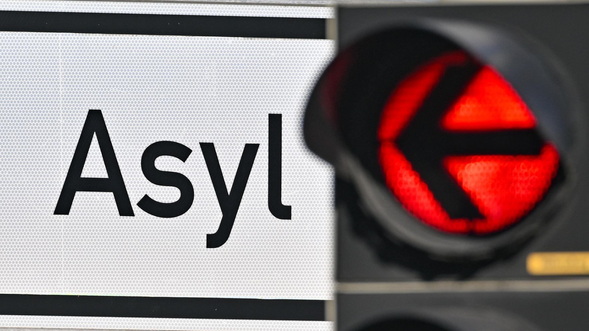 Eine rote Ampel und ein Schild auf dem "Asyl" steht.