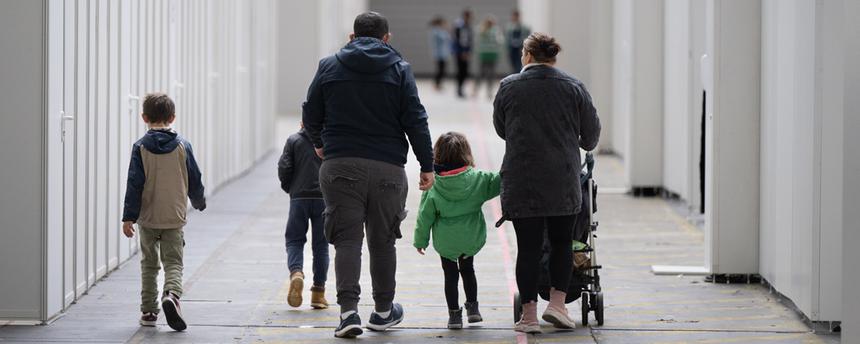 Eine Flüchtlingsfamilie geht durch die zu einer Massenunterkunft umfunktionierten Messehalle in Frankfurt. (Archivbild) 