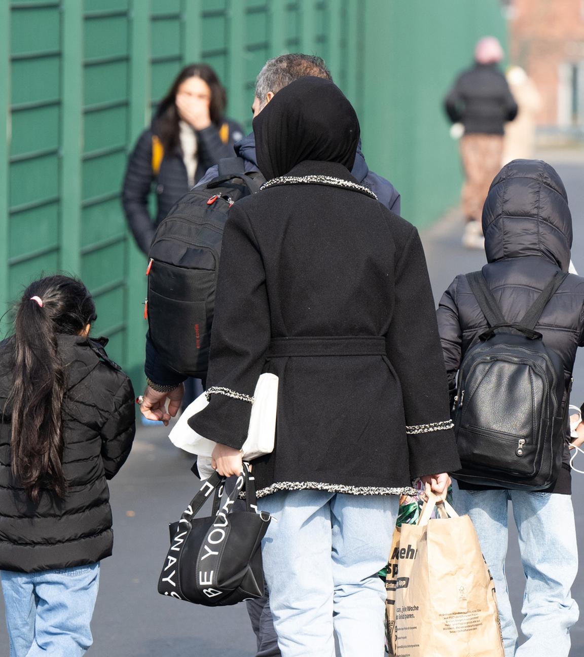Flüchtlinge gehen in der hessischen Erstaufnahmeeinrichtung für Flüchtlinge in Gießen zu einer Unterkunft. (Archiv)