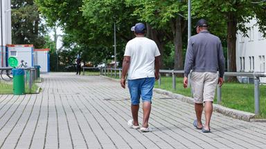 FlüchtlingsaufnahSymbolbild: Zwei Bewohner gehen in der Zentralen Aufnahmeeinrichtung für Asylbewerber in Bayern über das Gelände.me in Zirndorf