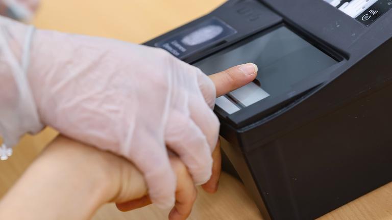  In der Zentralen Aufnahmeeinrichtung für Asylbewerber in Bayern werden von einer Mitarbeiterin Fingerabdrücke einer Migrantin abgenommen.