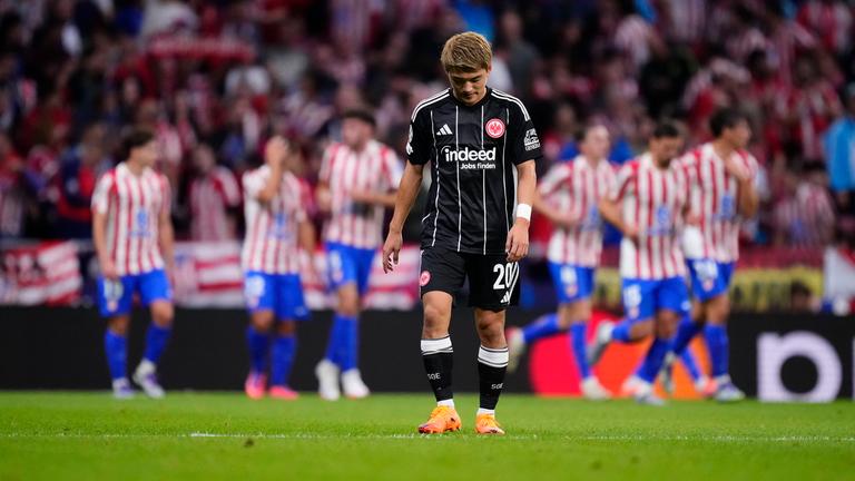 Atletico Madrid - Eintracht Frankfurt: Ritsu Doan steht bedrückt auf dem Platz, während im Hintergrund Atletico-Spieler jubeln.