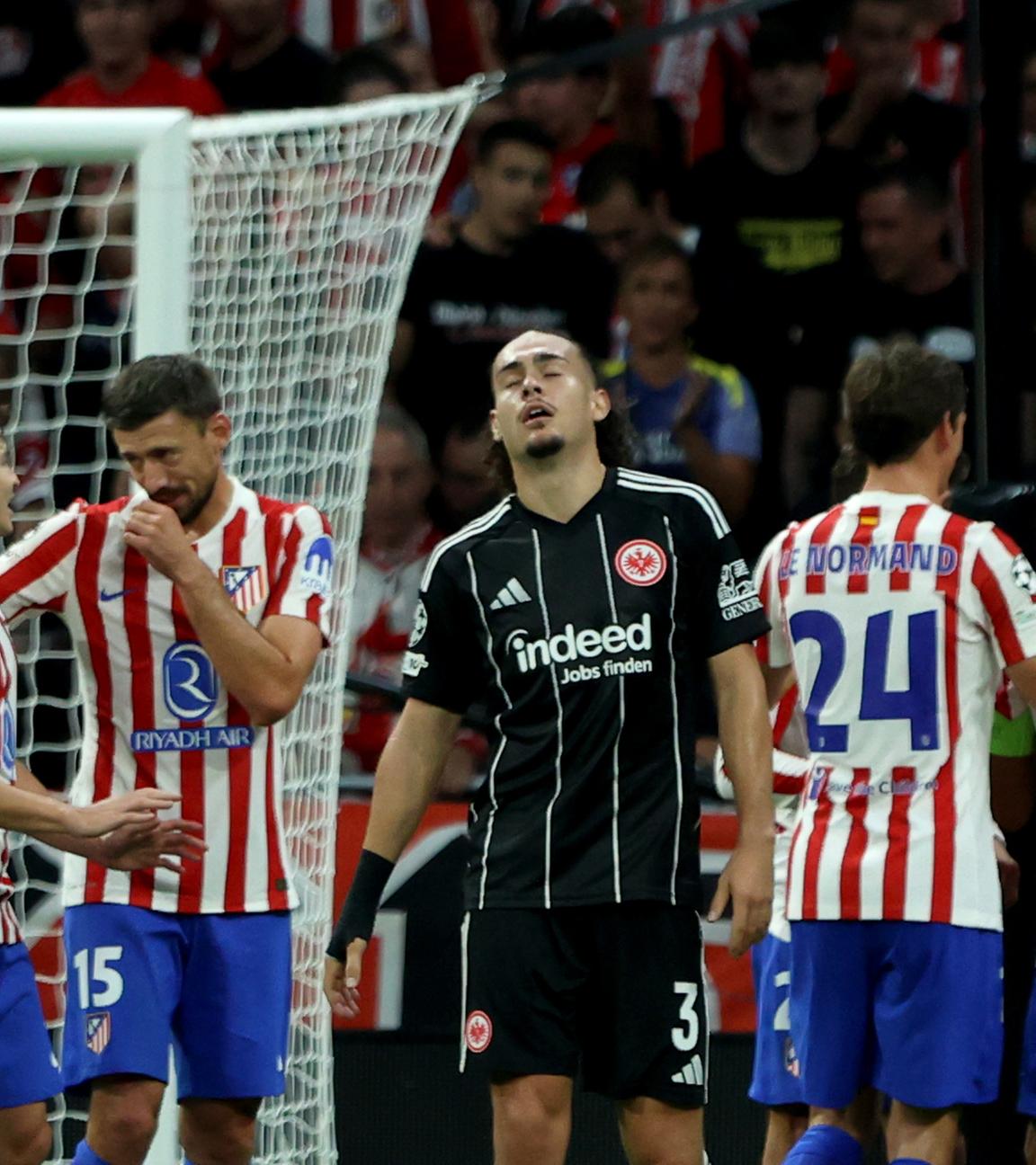 Atletico Madrid - Eintracht Frankfurt: Arthur Theate steht bedrückt auf dem Platz, während im Hintergrund Atletico-Spieler jubeln.