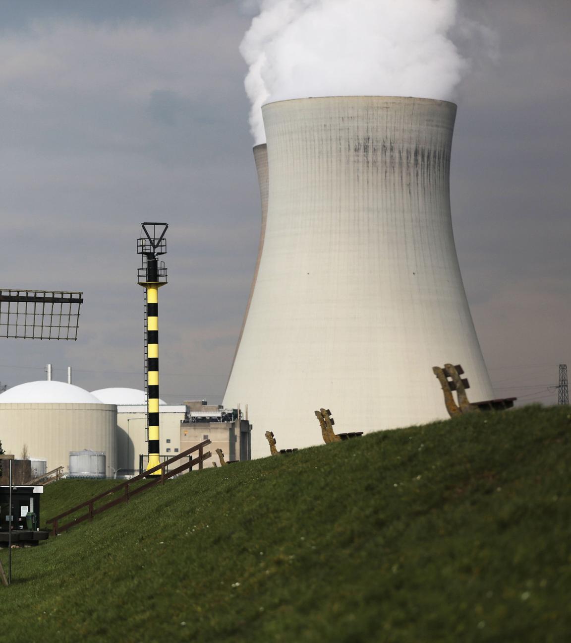 Belgien, Doel: Hinter der Windmühle von Doel steigt Dampf aus einem Atomkraftwerk