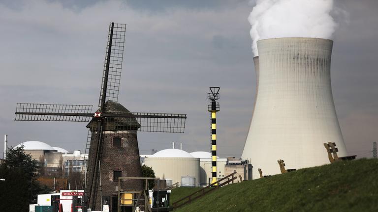 Belgien, Doel: Hinter der Windmühle von Doel steigt Dampf aus einem Atomkraftwerk