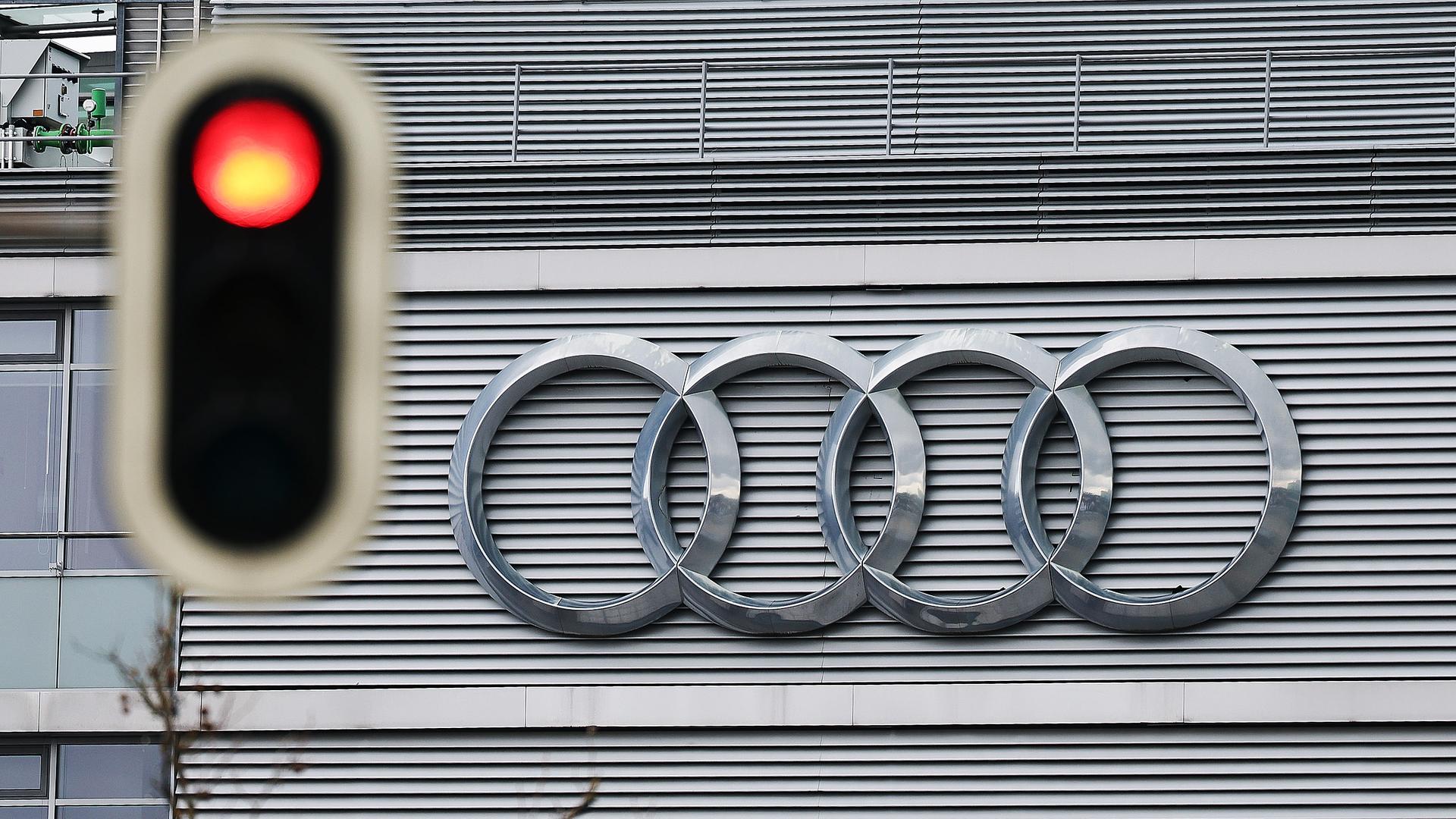 Das Logo von Autobauer Audi hinter einer roten Ampel.