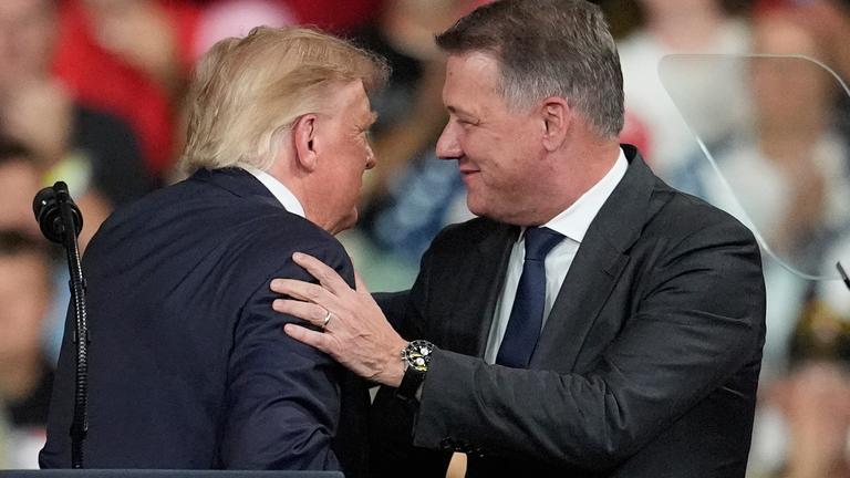 US-Präsident Donald Trump begrüßt Audi-CEO Gernot Döllner auf einer Wahlkampftribüne.