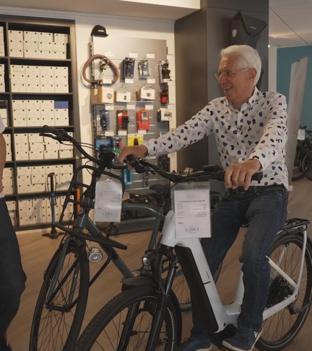 Ein Mann testet im Laden ein Fahrrad.