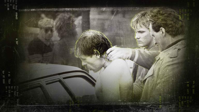 Ein Mann wird am Nacken gehalten und in ein Auto geführt.