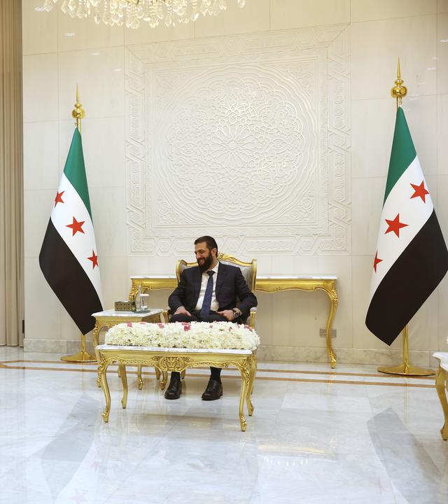 Der syrische Präsident Ahmed al-Scharaa (r) trifft sich im Präsidentenpalast mit dem Kommandeur der kurdisch geführten Syrischen Demokratischen Kräfte, Mazloum Abdi (M,l).