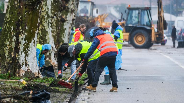 Volunteers clean up debris from streets after Storm Kristin passed through Embra in Marinha Grande