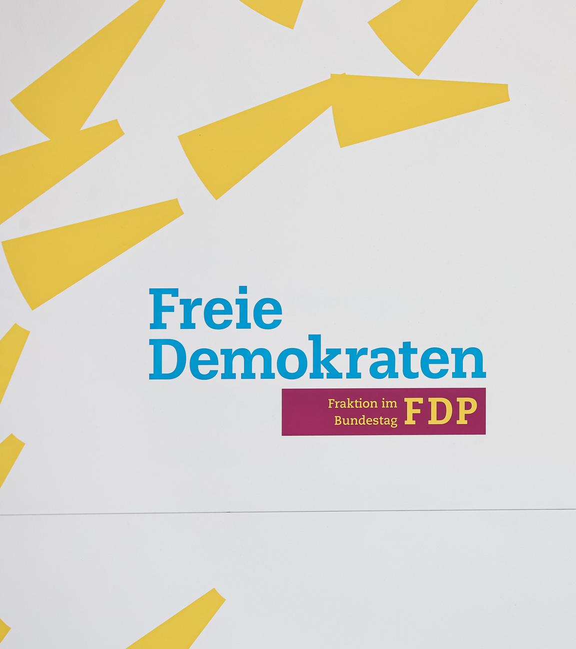 Berlin: Handwerker demontieren einen Aufsteller der FDP im Bundestag.