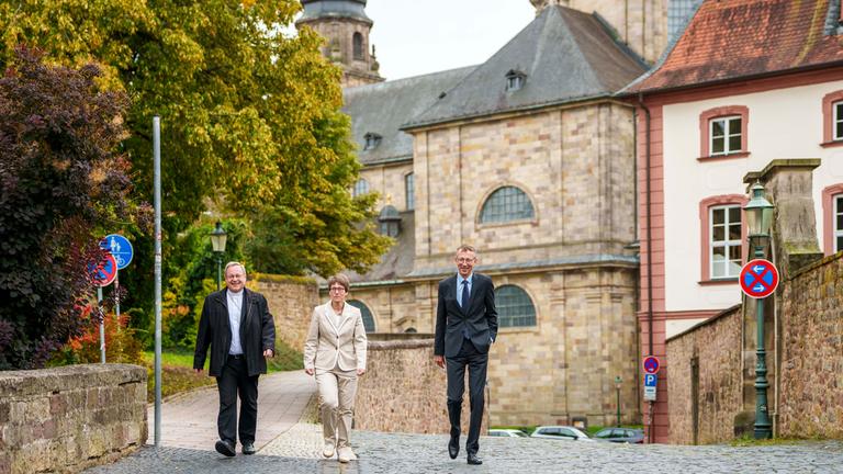 Hessen, Fulda: Bischof Georg Bätzing (l-r), Vorsitzender der Deutschen Bischofskonferenz, Beate Gilles, Generalsekretärin der Deutschen Bischofskonferenz, und Matthias Kopp, Pressesprecher, gehen zur Pressekonferenz zum Auftakt der Bischofskonferenz. 