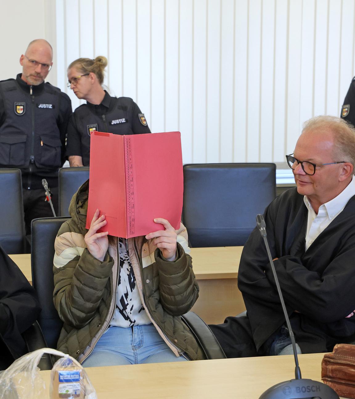 Mecklenburg-Vorpommern, Rostock: Andreas Ohm (l-r), Anwalt, die Angeklagte und Thomas Löcker, Anwalt, warten im Saal des Landgerichts auf den Beginn des Mordprozesses im Fall Fabian. 