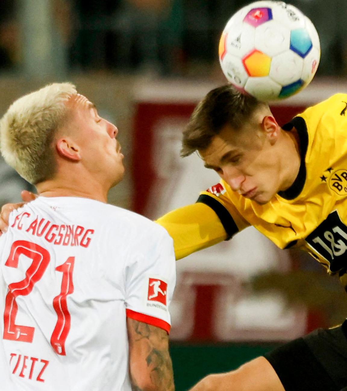 Augsburgs Phillip Tietz und Dortmunds Nico Schlotterbeck im Kampf um den Ball am 16.12.2023.
