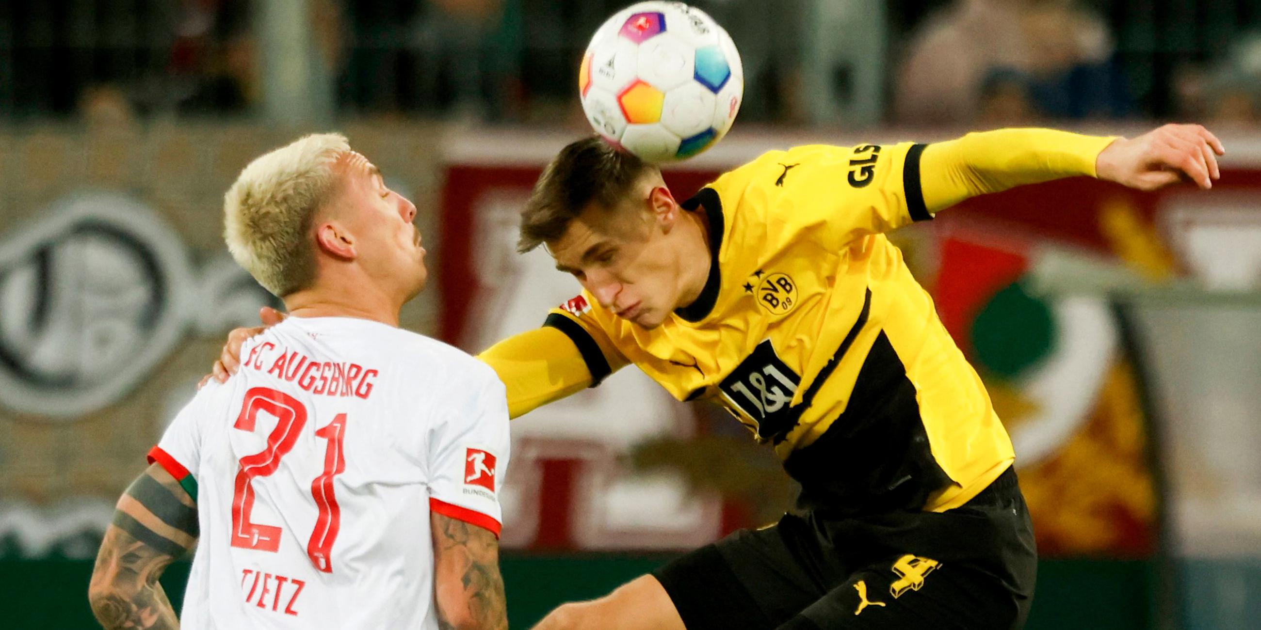 Augsburgs Phillip Tietz und Dortmunds Nico Schlotterbeck im Kampf um den Ball am 16.12.2023.