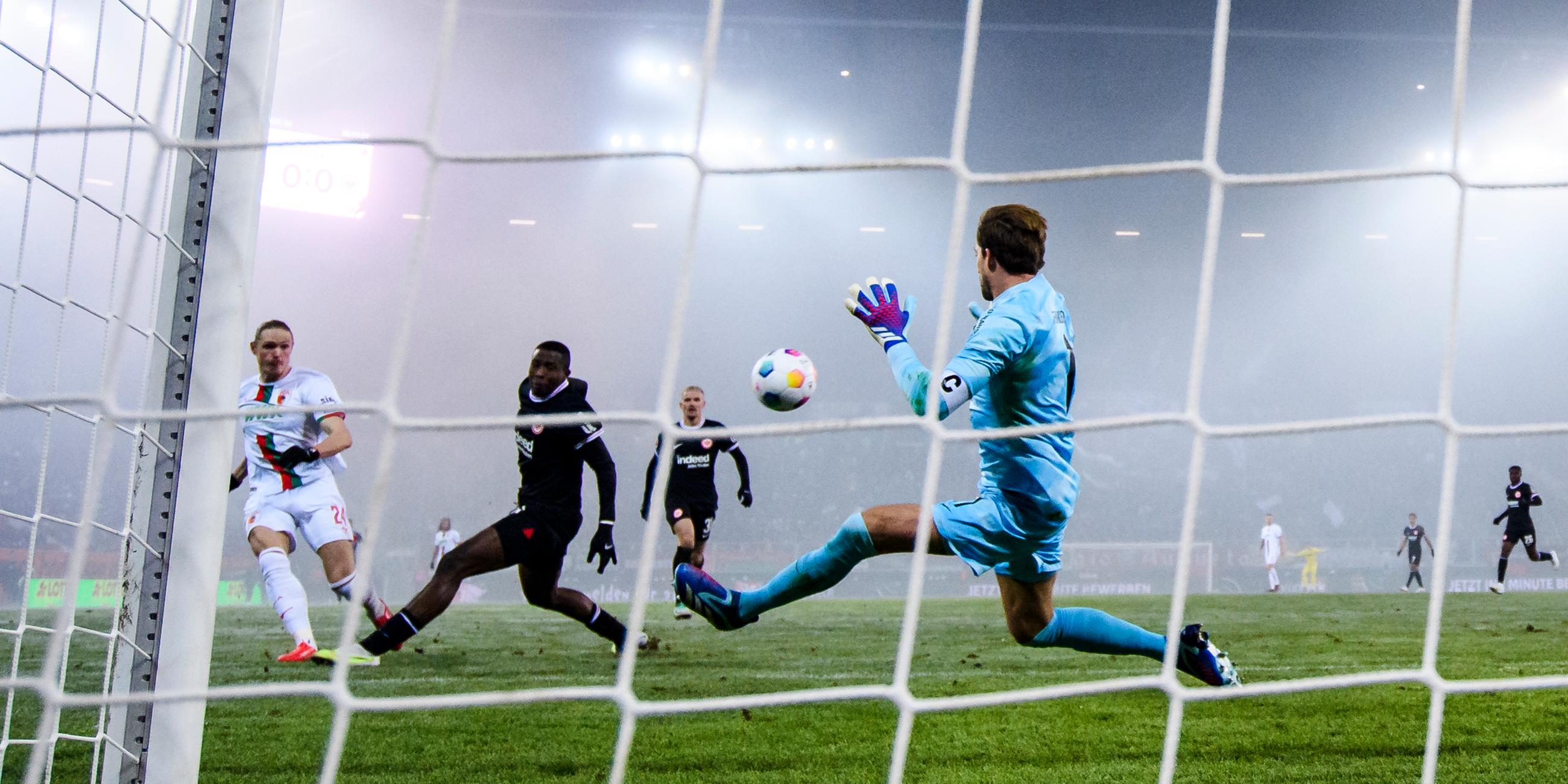 Augsburgs Fredrik Jensen macht das Tor zum 1:0 gegen Frankfurts Torwart Kevin Trapp am 03.12.2023.