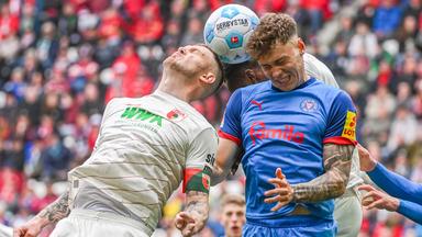 Nicolai Remberg von Kiel und Jeffrey Gouweleeuw von Augsburg im Kampf um den Ball.