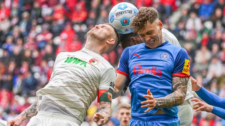 Nicolai Remberg von Kiel und Jeffrey Gouweleeuw von Augsburg im Kampf um den Ball.