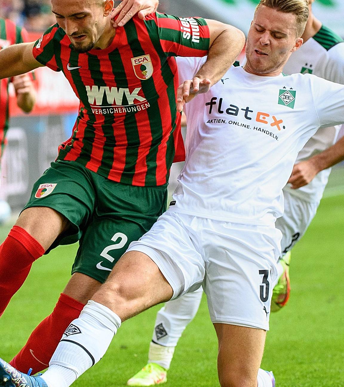 18.09.2021, Bayern, Augsburg: Fußball: Bundesliga, FC Augsburg - Borussia Mönchengladbach, 5. Spieltag in der WWK-Arena. Andi Zeqiri von Augsburg (l) und Nico Elvedi von Mönchengladbach im Zweikampf um den Ball. 
