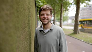 Auke Bleij steht neben einer Wand mit Moos und schaut in die Kamera.