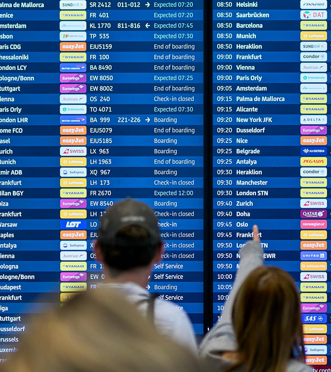 Fluggäste informieren sich an den Abflugtafeln im Terminal 1 des Flughafens Berlin Brandenburg.