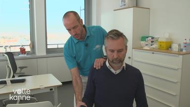 Ein Arzt behandelt die Schulter eines Mannes. 