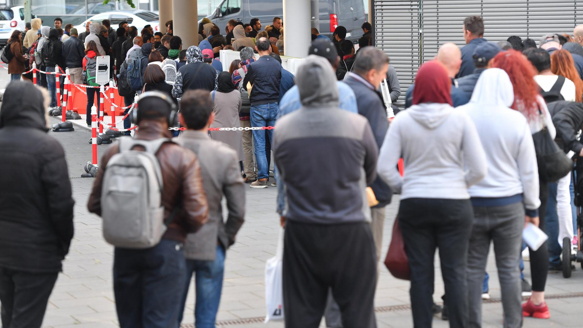 Zahlreiche Menschen stehen am Eingang der Ausländerbehörde in Frankfurt am Main (Hessen) Schlange. Archivbild