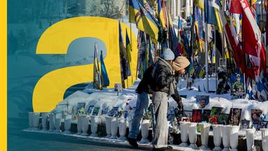 Menschen legen Blumen am Majdan Nesaleschnosti in Kiyv nieder. 