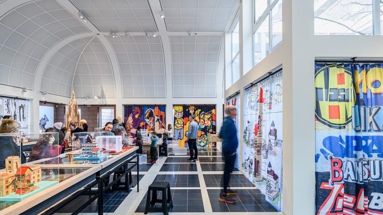 In einem Ausstellungsraum stehen Schaukästen. Menschen schauen sich die Exponate an.