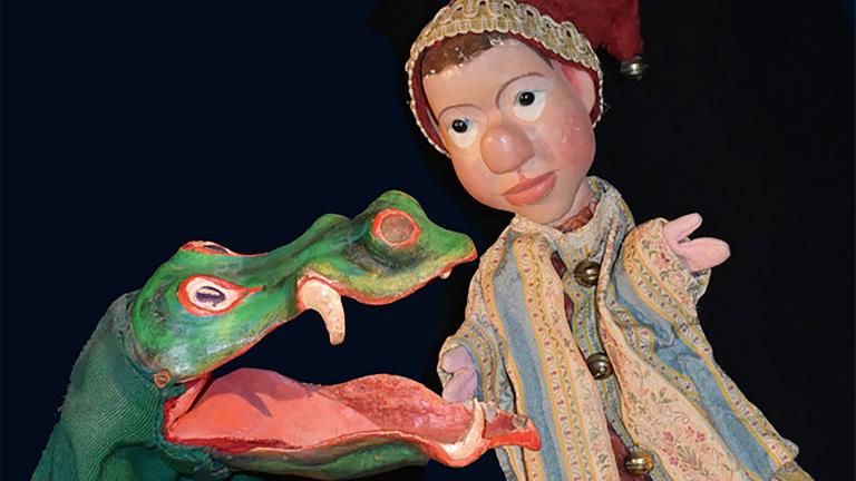 Eine Kasperl-Figur steht links neben einer Krokodils-Handpuppe.