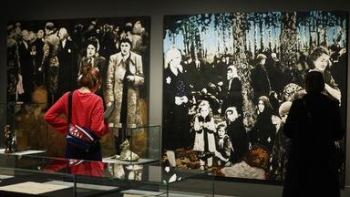 Ausstellungsbesucher stehen vor dem Gemälde An der Rampe von Klaus Steinke.