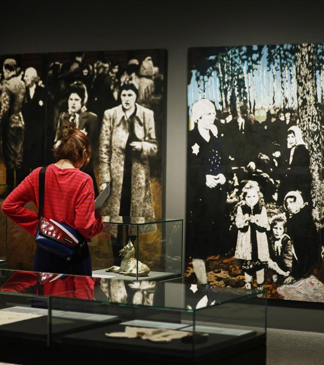 Ausstellungsbesucher stehen vor dem Gemälde An der Rampe von Klaus Steinke.
