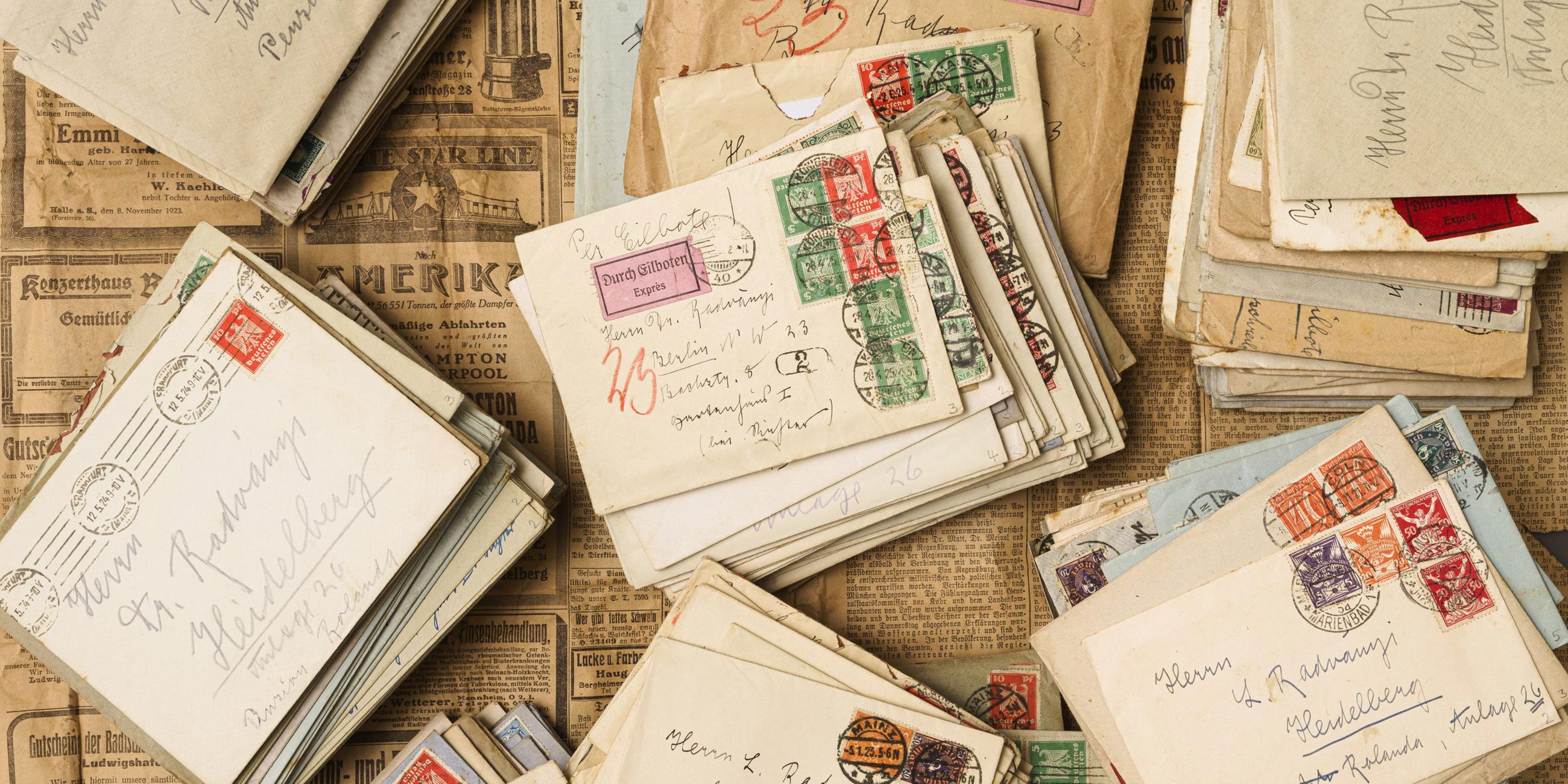 Auf historischen Zeitungen liegen historische Briefe.