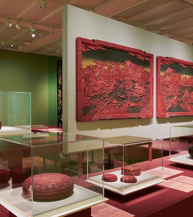 Ausstellungsraum mit hängenden und liegenden roten Lackkunstwerken.