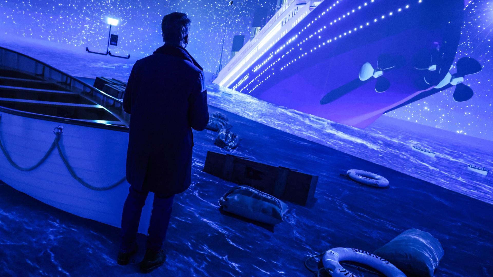 Ein Besucher steht in der Ausstellung ·Titanic: Eine Immersive Reise· in einer Simulation, die den Untergang aus Sicht der Rettungsboote darstellt. 