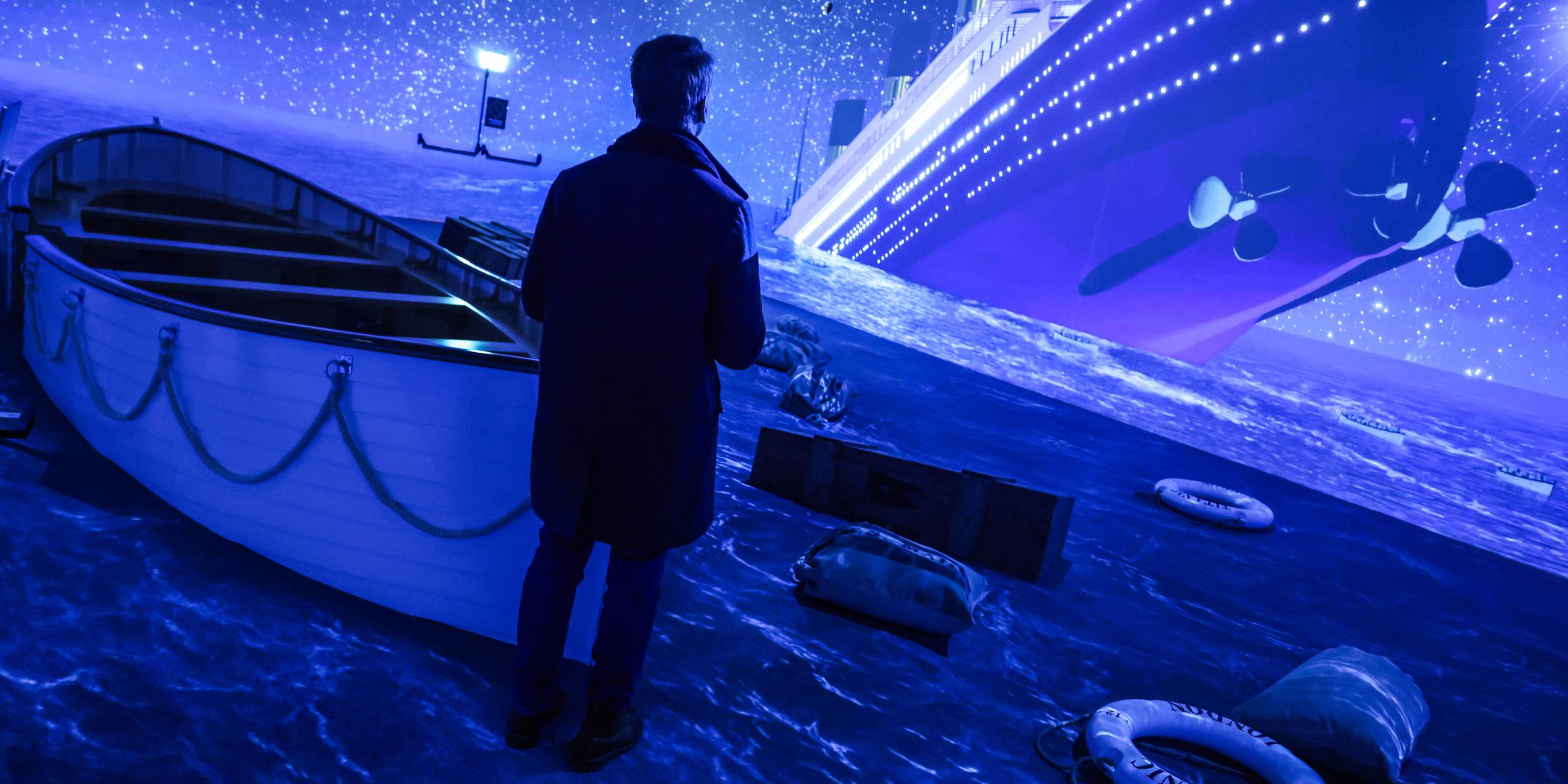 Ein Besucher steht in der Ausstellung ·Titanic: Eine Immersive Reise· in einer Simulation, die den Untergang aus Sicht der Rettungsboote darstellt. 
